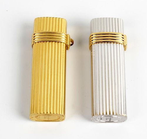 A pair of lighters by Christian Dior. Comprising a gold plated example, and another base metal, both