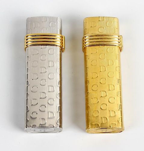 A pair of lighters by Christian Dior. Comprising a white gold plated example stamped Plaque OR G, an
