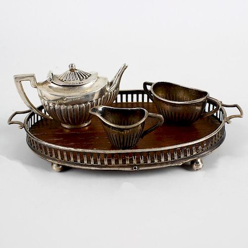 An Edwardian silver miniature tea service and tray. Comprising reeded oval teapot,1.9(4.8cm) long, a