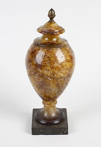 A Blue John 9th century urn. Of sectional form having brass acorn finial, the ovoid body of cream br