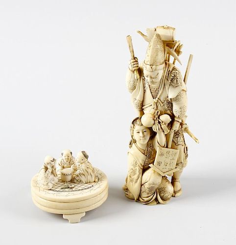 A 19th century carved ivory okimono, modelled as a male laden with sword and other tools, a female a