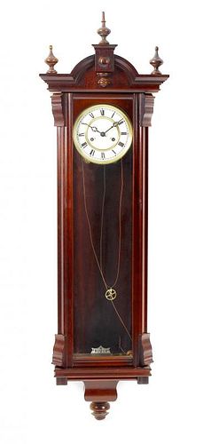 A reproduction Vienna style wall clock. The mahogany veneered case with arched pediment above a glaz