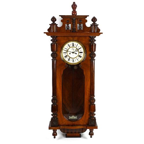 A Gustav Becker walnut and mahogany cased Vienna style wall clock. The shaped pediment above a shape