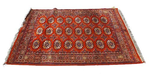 Two Eastern rugs. Comprising a Belouch/Tekke Turkoman type with three rows of eight guls on a tomato