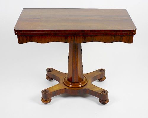 An early Victorian rosewood fold-over pedestal card table. The rounded oblong top enclosing a circul