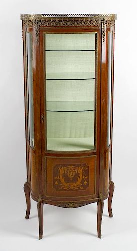 A 20th century French bow front vitrine or display cabinet Having a pierced gilt metal gallery over