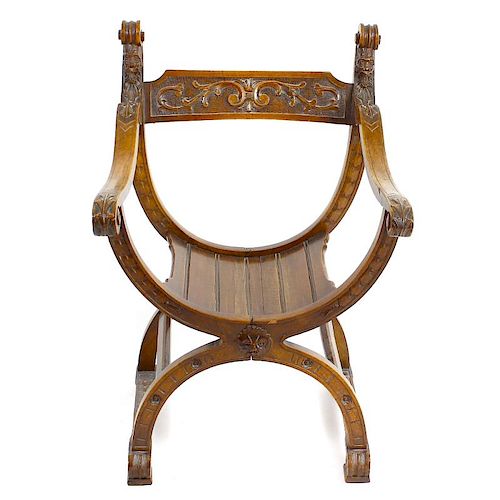 A late 19th century Continental carved walnut X-frame chair. The toprail decorated with foliate scro