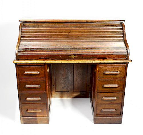 An early 20th century oak tambour pedestal desk. The S-shaped tambour enclosing drawers and pigeonho