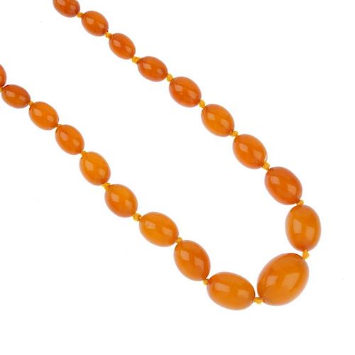 A natural Baltic amber necklace. The forty-three graduated oval beads measuring 2.8 to 0.8cms, to th