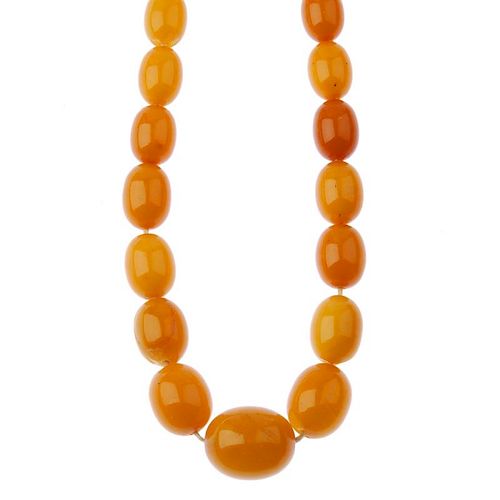 A natural amber bead necklace. Comprising fifty-five oval-shape, graduated natural amber beads measu