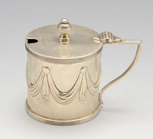 An Edwardian silver mustard pot, the drum form embossed with swags within reeded borders, hinged cre