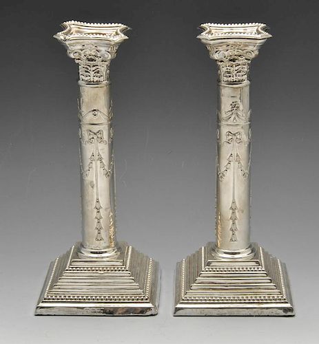 A pair of 1960's silver candlesticks, having raised garland swags tied with bows and pendant drops t