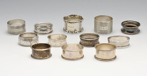 A selection of eleven assorted silver napkin rings and one plated example, of varying shapes and sty