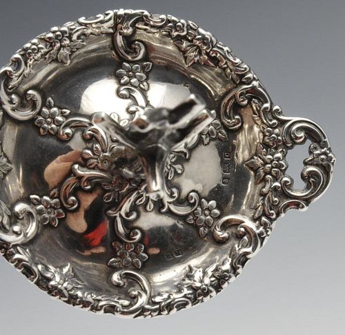 An Edwardian silver ring tree, the twin-handled circular form decorated with floral scrolls and risi