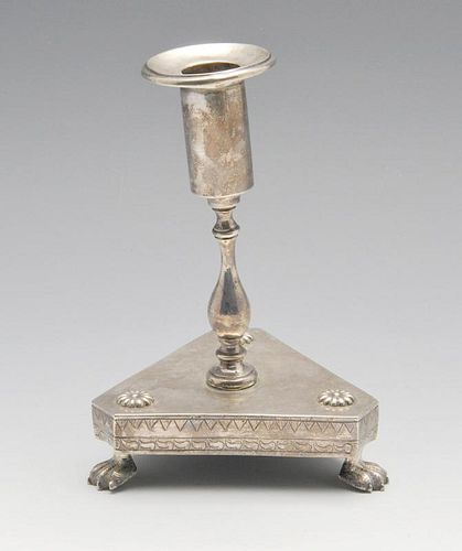 A South American candlestick of tri-form, florally embellished base raised on three paw feet and ris