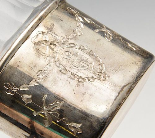 An Edwardian silver mounted hip flask, the clear glass body with faceted shoulders, the detachable c