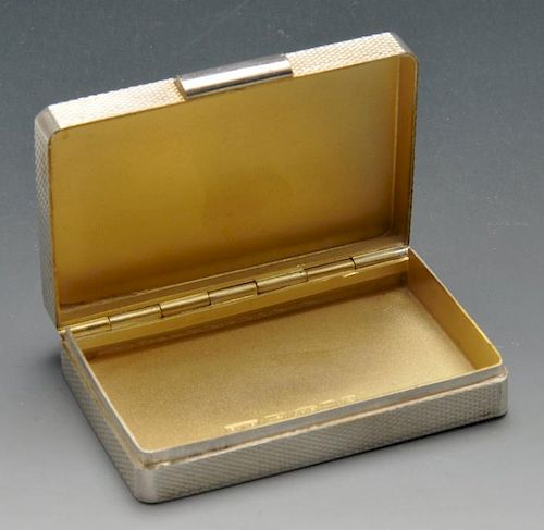 A modern silver pill box of rectangular form having engine turned exterior to the whole and with ini