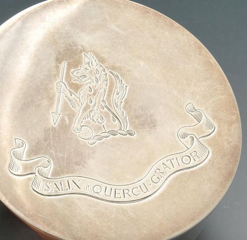 A modern silver box of circular form, the cover with crest and motto engraving and opening to a silv