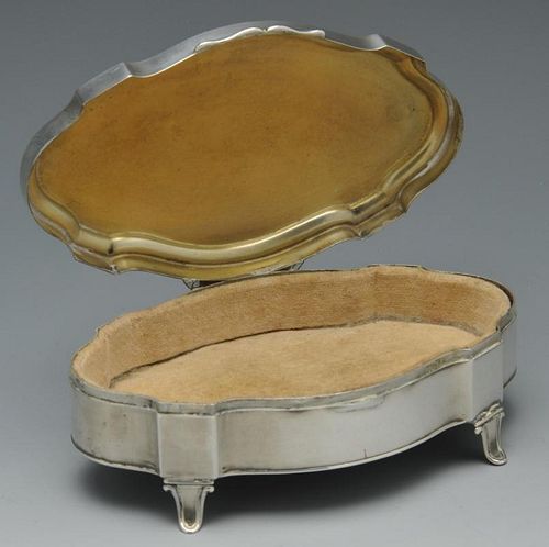An early twentieth century silver mounted trinket box of shaped oval outline and raised on four spla
