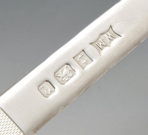 A modern silver letter opener, the plain tapering blade leading to the engine-turned handle. Hallmar