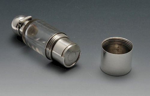 A Victorian combination scent bottle and sovereign holder, the clear glass cylindrical body with dom