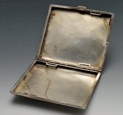 A continental cigarette case, the rounded rectangular form with circular enamel panel to the front d