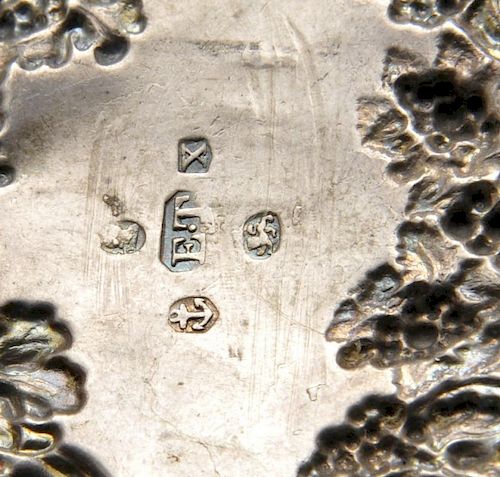 A George IV silver wine label, the scalloped scroll surround with fruiting vine, surmounted with Bac