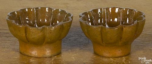 Pair of John Bell small redware molds, 19th c., with a scalloped rim and pinwheel center