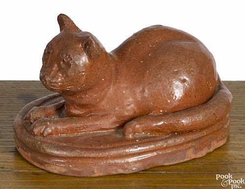 Redware figure of a recumbent cat, 19th c., on a slab base, with incised features, 3'' h., 5 1/4'' w