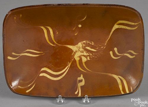 Redware loaf dish, 19th c., with yellow slip decoration, 8'' h., 11 7/8'' w.