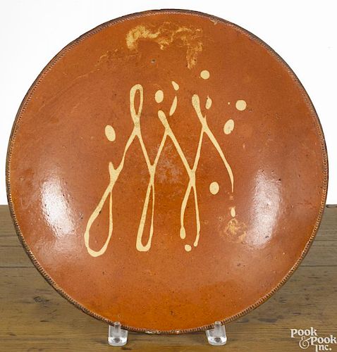 Connecticut redware charger, 19th c., with yellow slip loop decoration, 13 3/8'' dia.