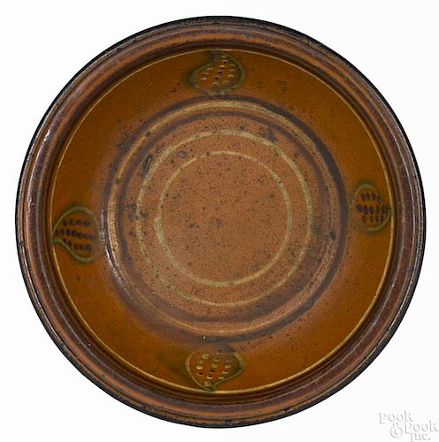 Pennsylvania or Maryland redware bowl, 19th c., with slip concentric bands and four leaf devices