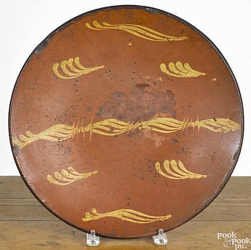 New England redware charger, 19th c., with yellow slip decoration, 14 5/8'' dia.