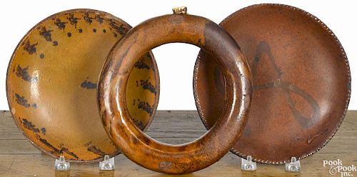 Two redware pie plates, 19th c., 7 3/4'' dia., together with a ring flask, 8'' dia.