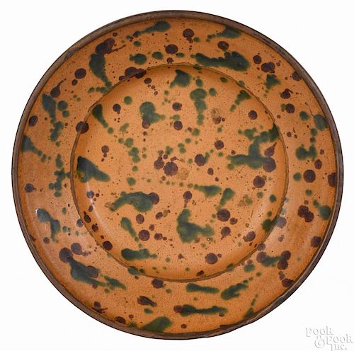 Redware bowl, 19th c., with bold green and brown slip polka dot decoration on an orange ground