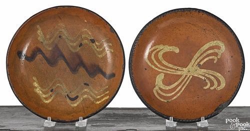 Two Pennsylvania slip decorated redware pie plates, 19th c., 8 1/4'' dia. and 8 1/2'' dia.