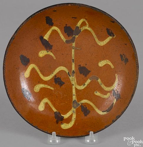 Pennsylvania redware pie plate, 19th c., with yellow slip and manganese splash decoration, 8'' dia.