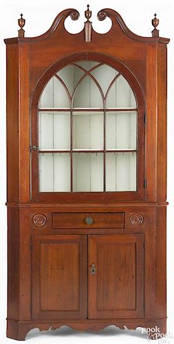 Pennsylvania pine two-part corner cupboard, ca. 1830, retaining a red stain surface, 84'' h.,