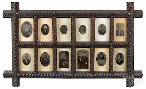 Tramp art carved twelve-space picture frame, ca. 1900, filled with tin type portraits, 13 1/4'' x 22''