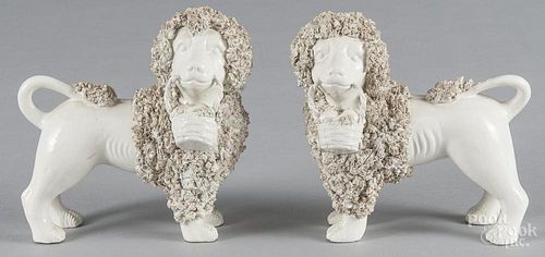 Pair of ceramic spaniels, 19th c., holding fruit baskets, with heavy coleslaw decoration, 7 1/4'' h.