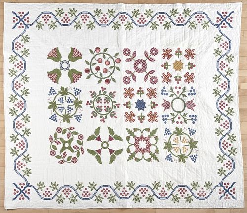 Contemporary cross stitch sampler quilt with a trailing vine border, 92'' x 80''.