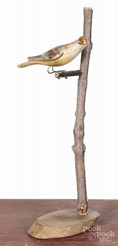 Carved and painted bird, ca. 1900, mounted to a twig stand, 13'' h.