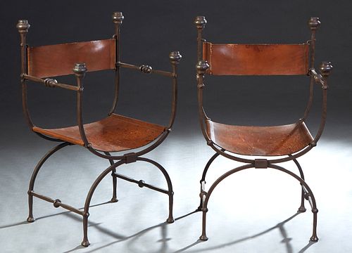 Pair of Wrought Iron and Leather Savonarola Style Arm Chairs, late 19th c., the leather back with stepped finial posts to ringed iron arms flanking a 