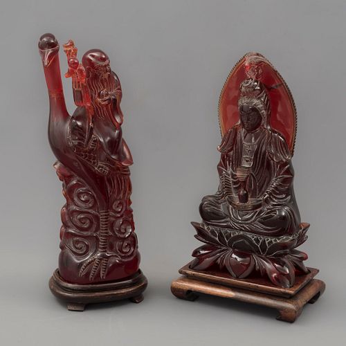 Lote de 2 deidades. Origen oriental, SXX. Elaborados en resina tipo ambar color rojo. Con bases de madera.