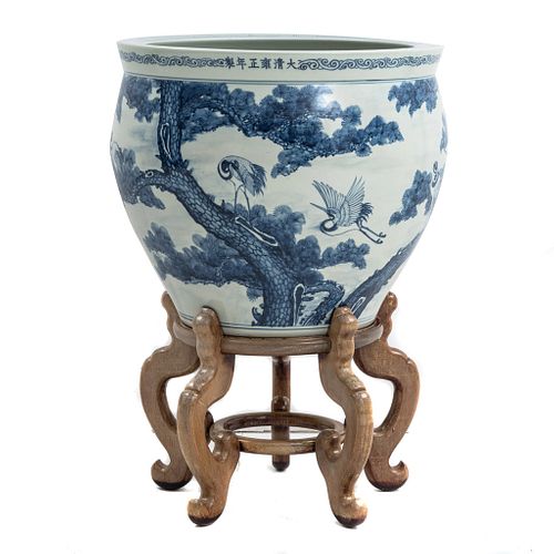 Pecera. China, SXX. Elaborada en cerámica con base de madera. Decorada con motivos orgánicos y grullas en azul cobalto.