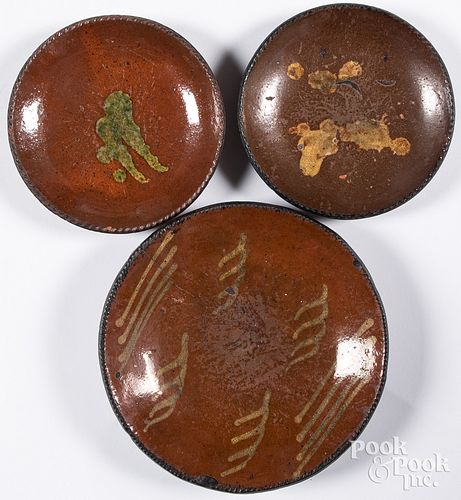 Three Pennsylvania slip decorated redware plates
