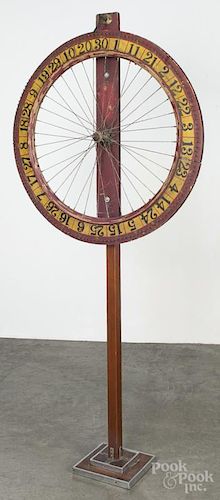 Painted pine game wheel, 19th c., mounted on a later stand, 68'' h., 31'' dia.