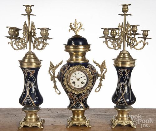French three-piece porcelain and tin clock set with a pair of candelabra, 19 1/2'' h.