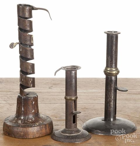 Three tin candlesticks, 19th c. to include one with a spiral shaft, 8 1/2'' h.