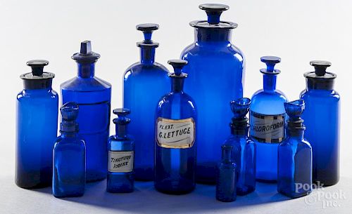 Twelve cobalt glass apothecary bottles, tallest - 11 3/4''.